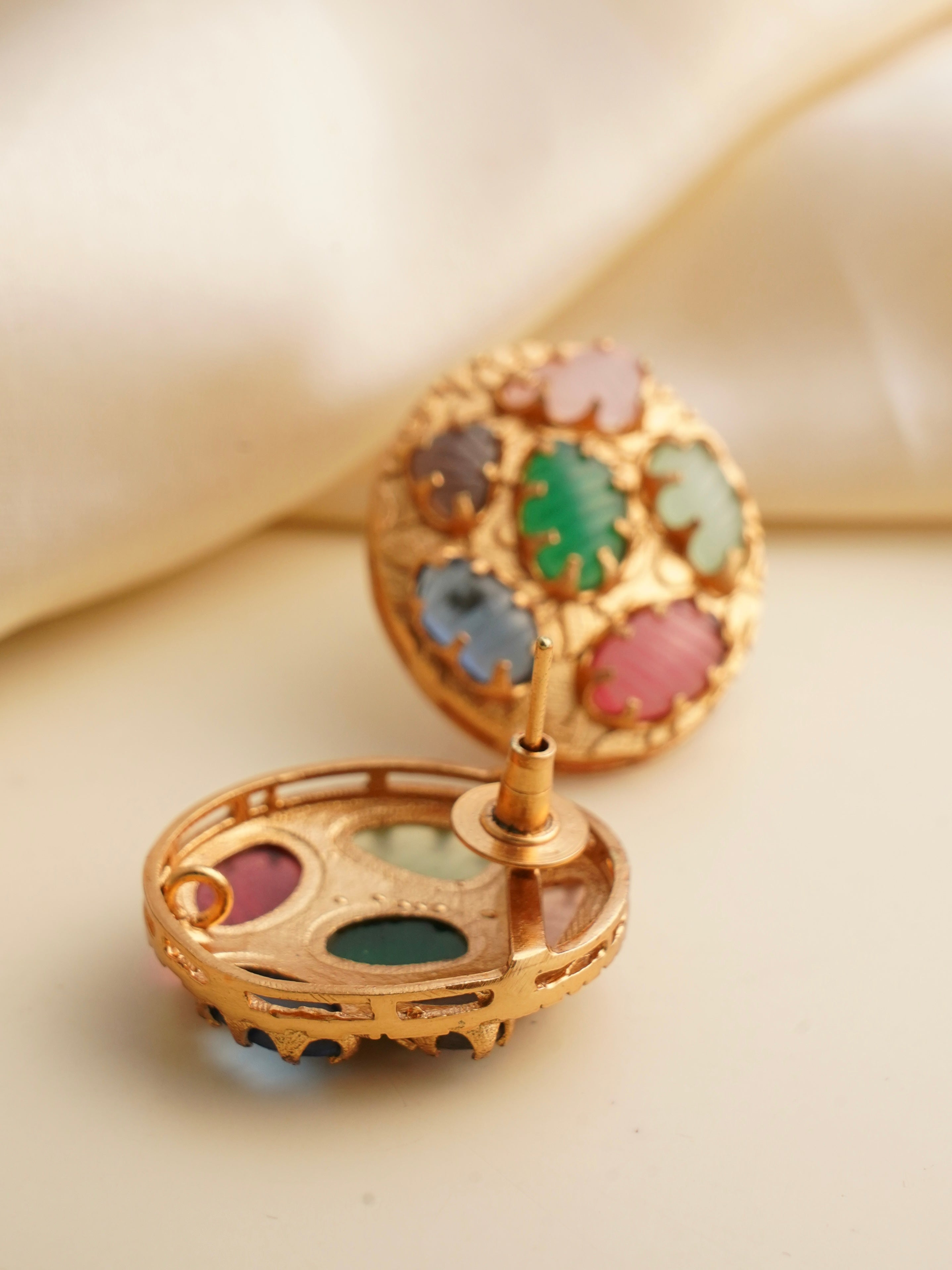 Rear view of navratna medallion stud showing screw‑back closure and multicolored gemstones